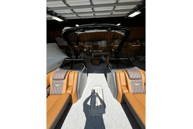 Slide: The Image of 2026 Bennington Swingback 25 interior with tan seating in a garage setting. - 11