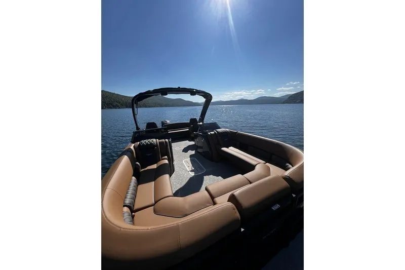 Slide: The Image of 2026 Bennington Swingback 25 boat on a sunny lake, featuring luxurious seating and scenic views. - 2