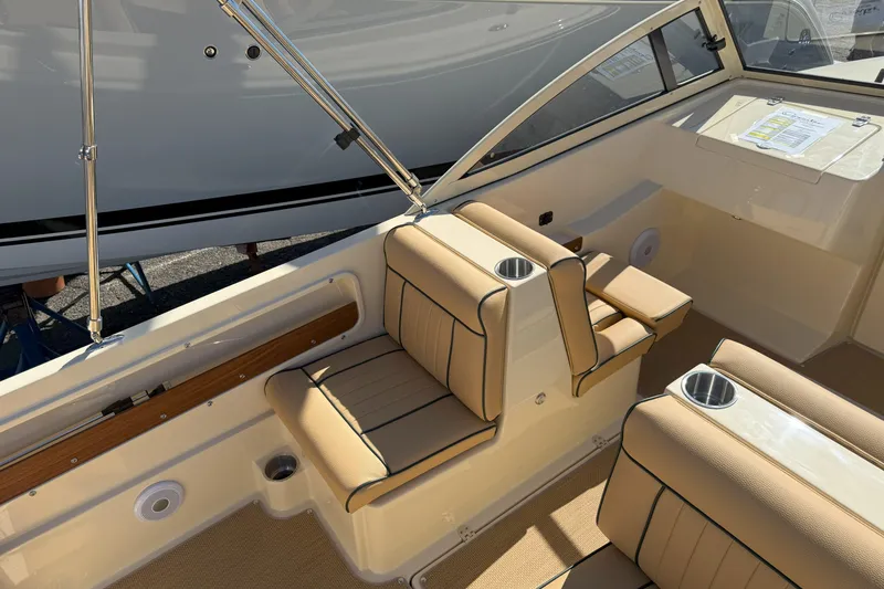 Slide: The Image of 2026 Rossiter 20 Day Boat interior with beige seating and cup holders. - 9