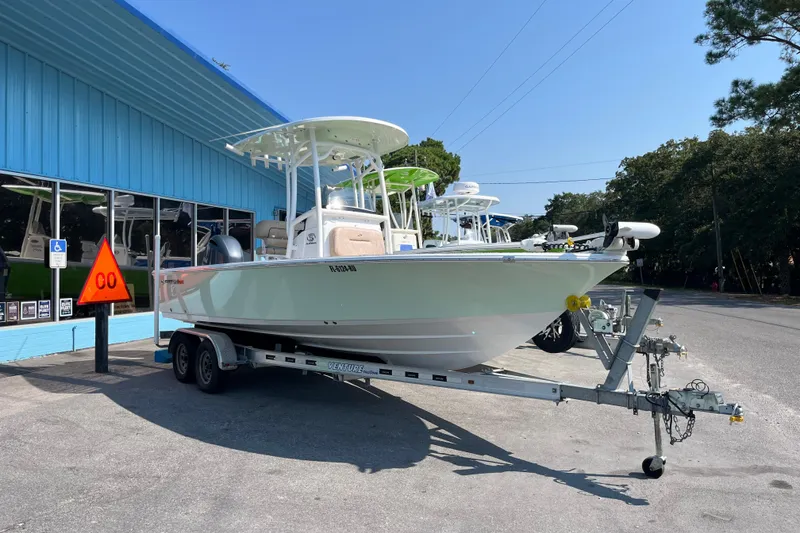 Slide: The Image of 2019 Sportsman Masters 227 Bay Boat on trailer outside blue building. - 2