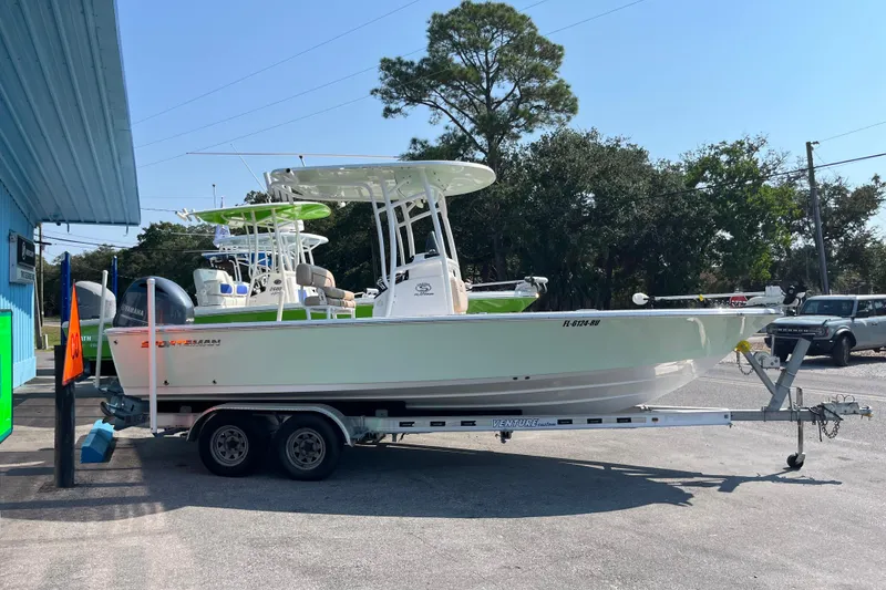Slide: The Image of 2019 Sportsman Masters 227 Bay Boat on trailer, parked outdoors near a blue building. - 3