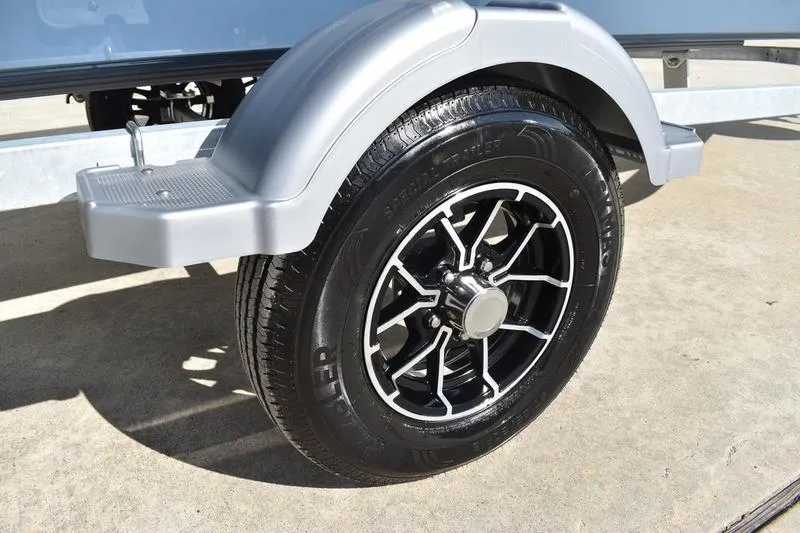 Slide: The Image of 2025 Lowe Roughneck RX1860 CC trailer wheel with sleek black and silver rim design. - 10