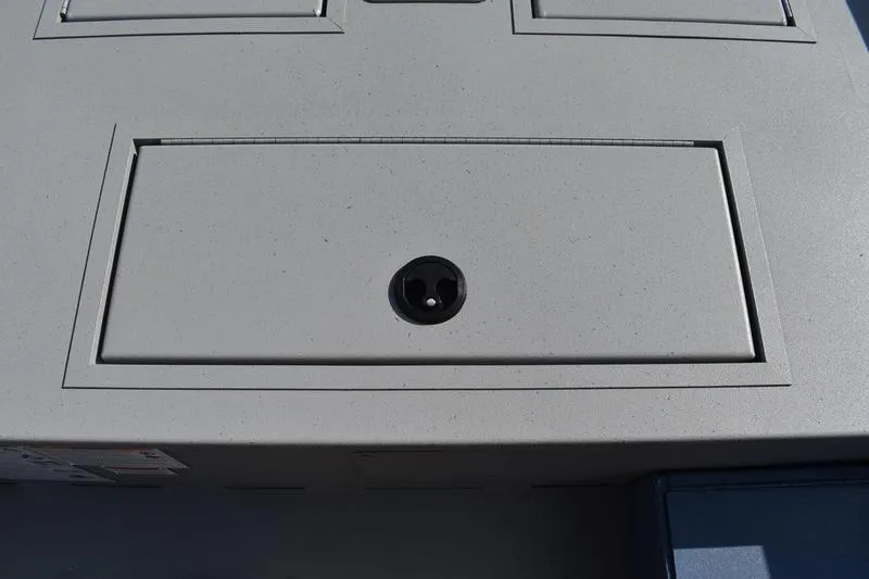 Slide: The Image of 2025 Lowe Roughneck RX1860 CC boat storage compartment with a circular handle. - 13