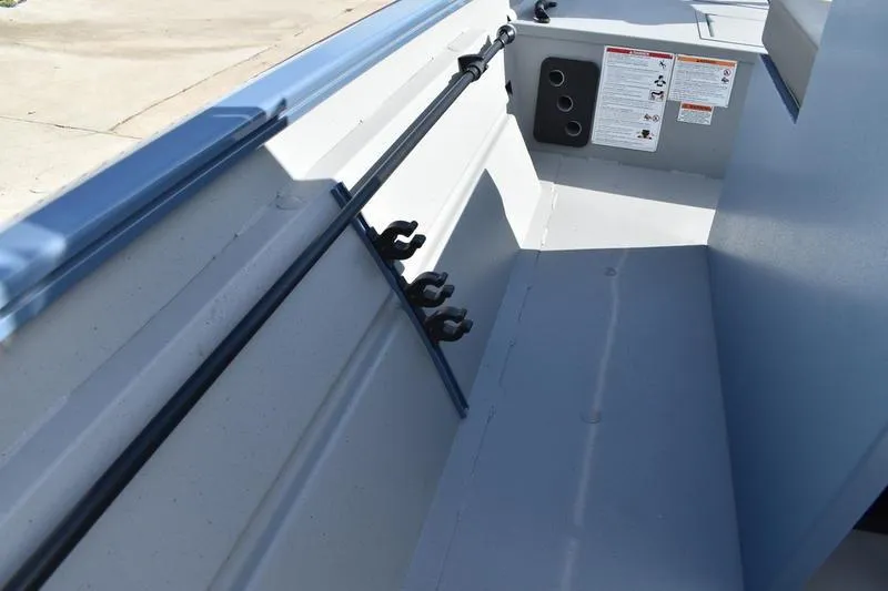 Slide: The Image of 2025 Lowe Roughneck RX1860 CC interior with rod holders and safety instructions. - 18