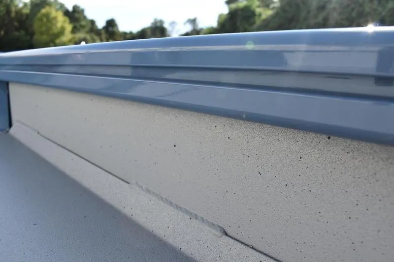 Slide: The Image of Close-up of 2025 Lowe Roughneck RX1860 CC boat's side detail, featuring sleek blue trim. - 27