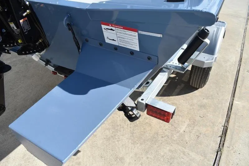 Slide: The Image of 2025 Lowe Roughneck RX1860 CC boat trailer with ramp and warning label. - 4