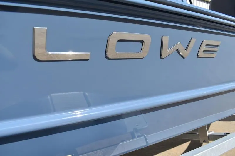 Slide: The Image of 2025 Lowe Roughneck RX1860 CC boat with metallic logo on blue hull. - 8