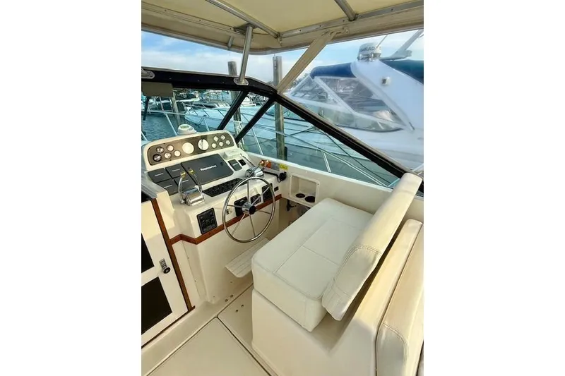 Slide: The Image of 1996 Pursuit 3100 Offshore boat docked at marina, American flag, sunset view. - 11