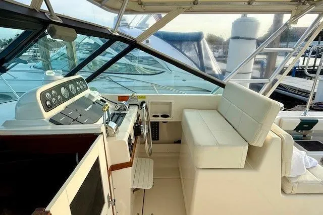 Slide: The Image of 1996 Pursuit 3100 Offshore boat interior with dual white seats and helm. - 12