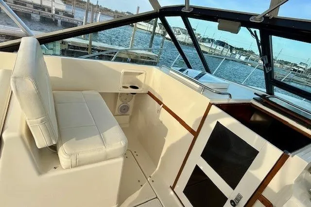 Slide: The Image of 1996 Pursuit 3100 Offshore boat cockpit with steering wheel and control panel. - 13