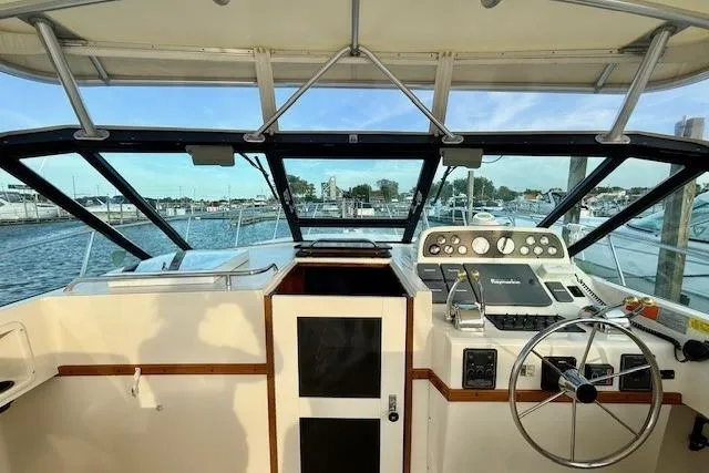 Slide: The Image of 1996 Pursuit 3100 Offshore boat interior with helm and seating area. - 14