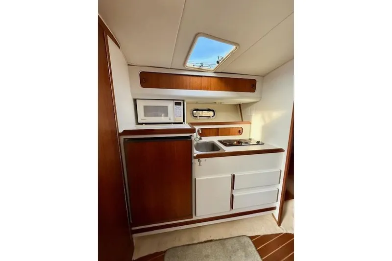 Slide: The Image of Interior of a 1996 Pursuit 3100 Offshore boat with cozy seating and wooden table. - 17
