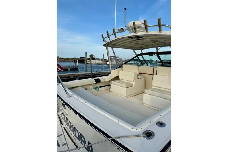 Slide: The Image of 1996 Pursuit 3100 Offshore boat docked in marina, featuring sleek design and American flag. - 5