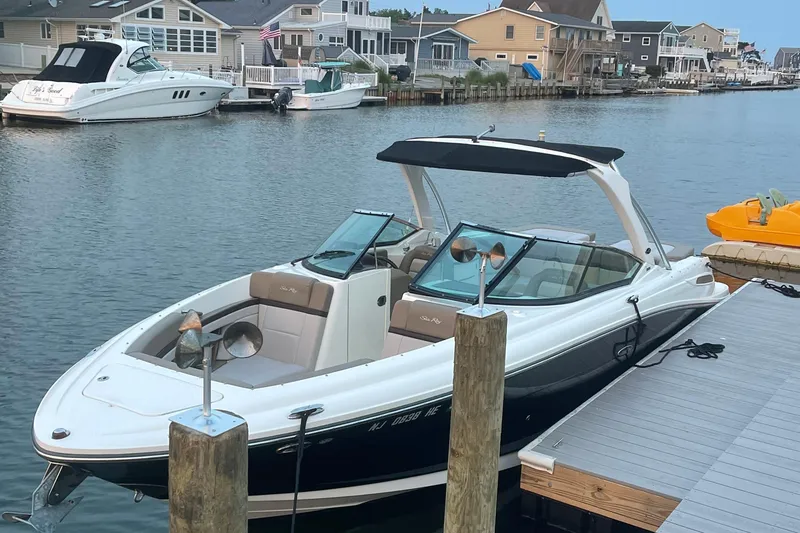 The Image of 2011 Sea Ray 270 SLX boat docked in a scenic waterfront neighborhood. - 0