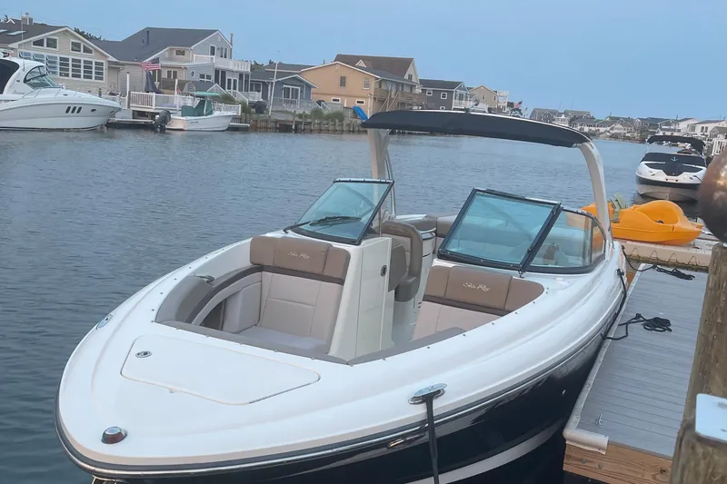 Slide: The Image of 2011 Sea Ray 270 SLX boat docked in a scenic waterfront neighborhood. - 2