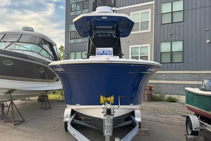 Slide: The Image of 2020 Blackfin 212 CC boat for sale, displayed on a trailer in a marina. - 1