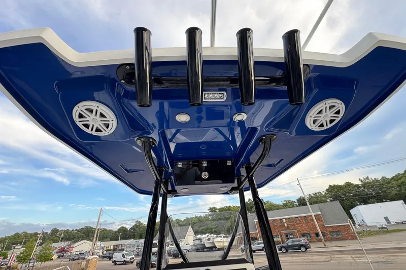 Slide: The Image of 2020 Blackfin 212 CC boat's T-top with speakers and rod holders, under a blue sky. - 13