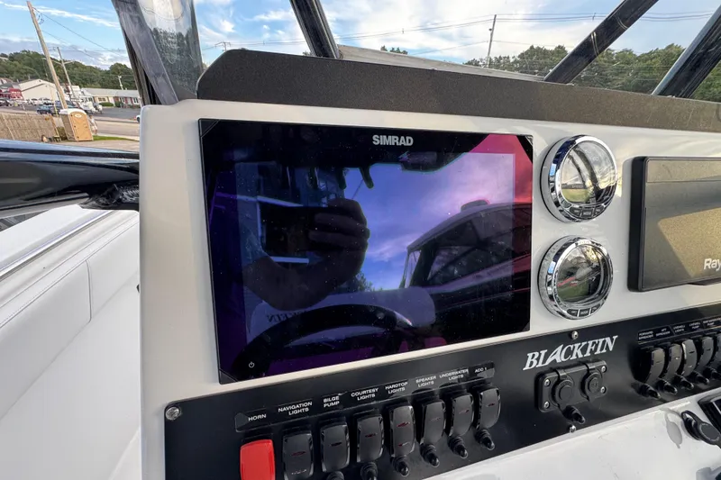 Slide: The Image of 2020 Blackfin 212 CC boat dashboard with Simrad display and control switches. - 16