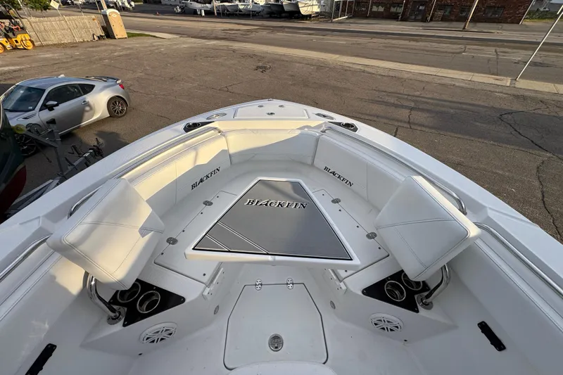 Slide: The Image of 2020 Blackfin 212 CC boat interior with white seating and branded flooring. - 22
