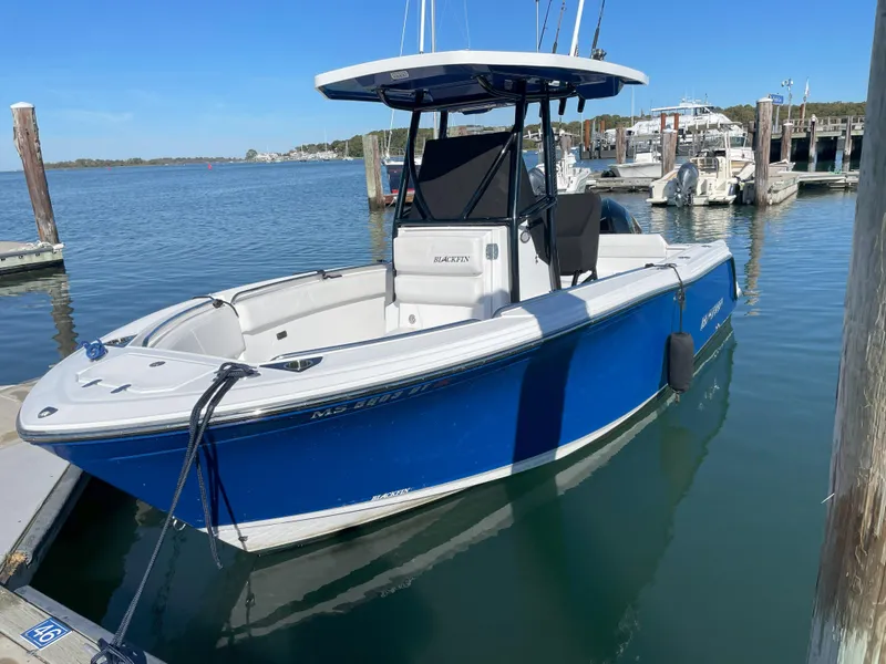 Slide: The Image of 2020 Blackfin 212 CC boat docked in marina, blue hull, calm water, clear sky. - 27