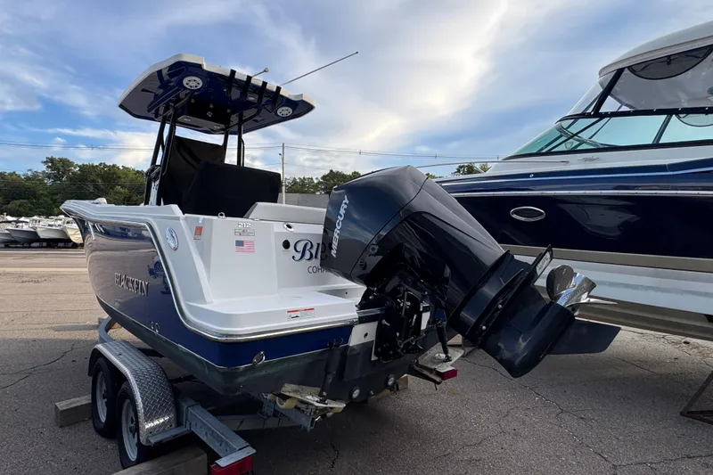 Slide: The Image of 2020 Blackfin 212 CC boat on trailer with Mercury outboard motor, parked outdoors. - 4
