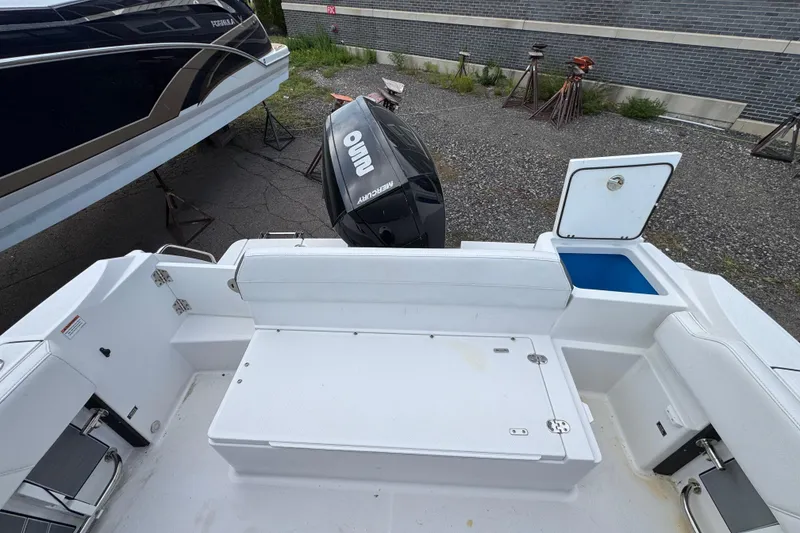 Slide: The Image of 2020 Blackfin 212 CC boat interior with Mercury engine, open storage compartment, and seating area. - 7