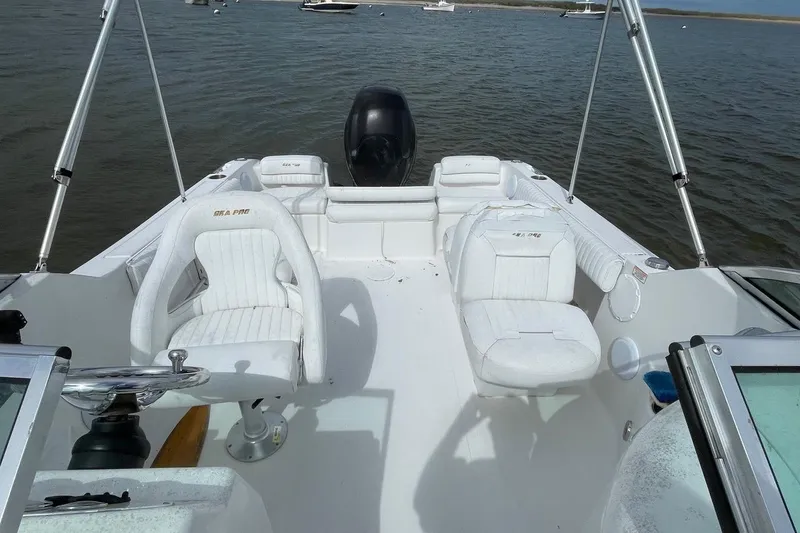 Slide: The Image of 2007 Sea Pro 216 boat interior with white seating and steering wheel on calm water. - 4