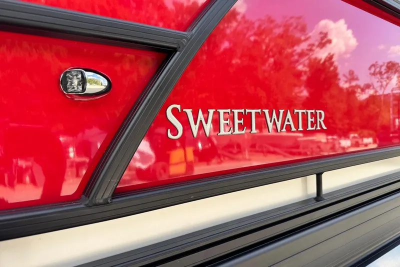 Slide: The Image of 2026 Godfrey SWEETWATER 2286 SB boat with red exterior and chrome lettering. - 6