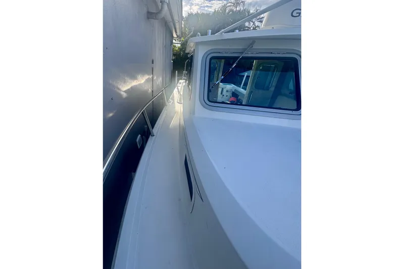 Slide: The Image of 2024 Parker 2320 Sport Cabin boat side view with cabin window and railing. - 14