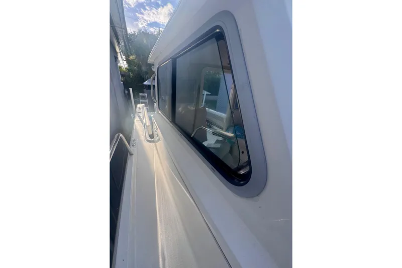 Slide: The Image of 2024 Parker 2320 Sport Cabin boat side view with window and railing. - 15