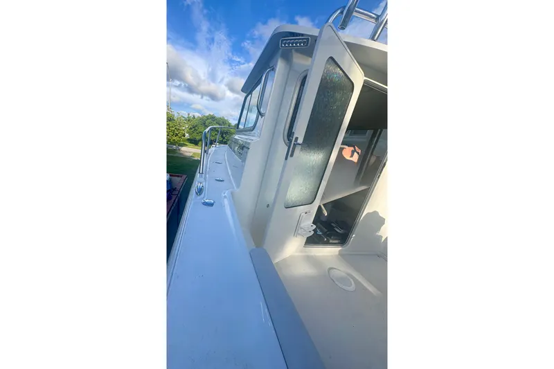 Slide: The Image of 2024 Parker 2320 Sport Cabin boat with open cabin door under blue sky. - 16