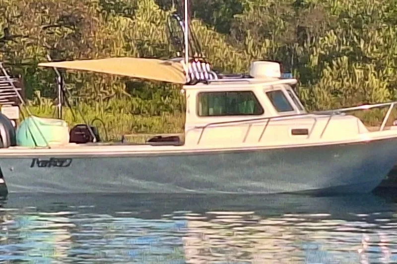 Slide: The Image of 2024 Parker 2320 Sport Cabin boat docked with Yamaha outboard motor. - 2