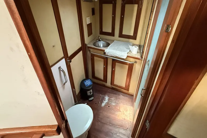 Slide: The Image of 1978 Marine Management 48 Sport Fish boat bathroom with sink, toilet, and wooden cabinetry. - 31