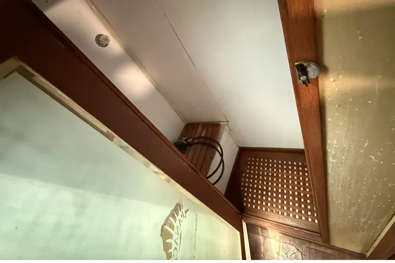 Slide: The Image of Interior view of a 1978 Marine Management 48 Sport Fish boat, featuring wooden paneling and storage space. - 32