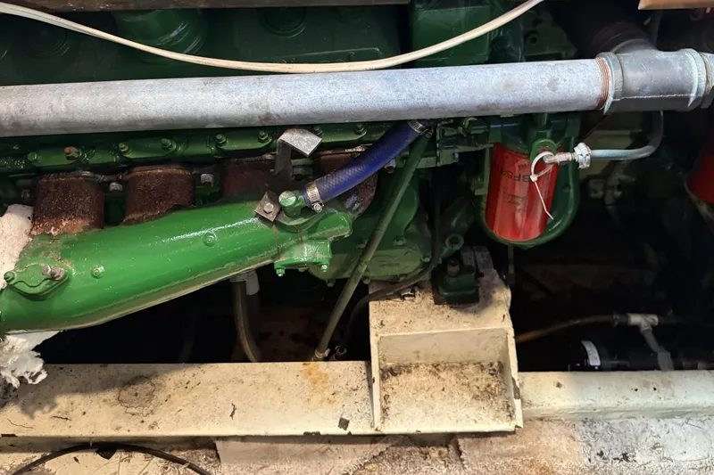 Slide: The Image of Engine compartment of a 1978 Marine Management 48 Sport Fish boat, showing green machinery and pipes. - 39