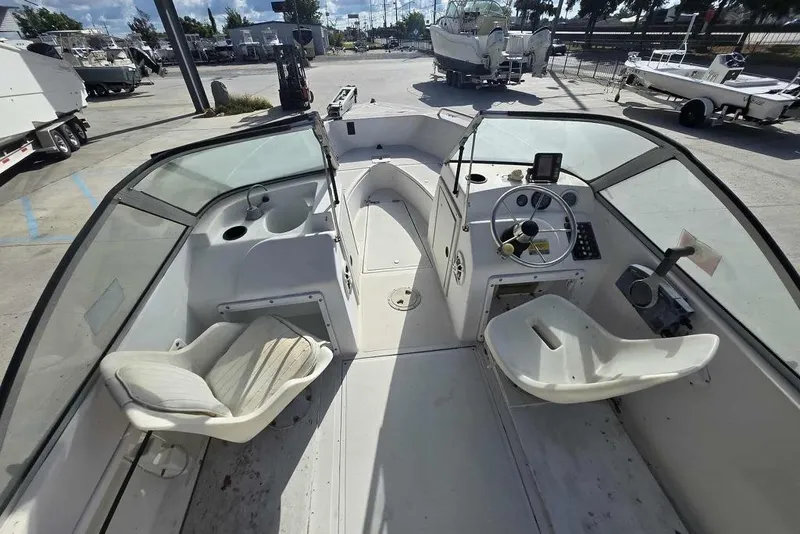 Slide: The Image of 1998 PROSPORT 20cc boat interior with steering wheel and seating in a marina setting. - 12