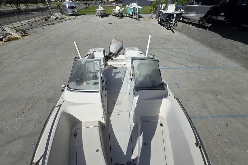 Slide: The Image of 1998 PROSPORT 20cc boat with dual consoles and outboard motor in a parking lot. - 14
