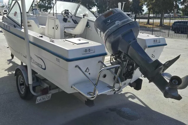 Slide: The Image of 1998 PROSPORT 20cc boat with outboard motor on trailer, parked outdoors. - 5