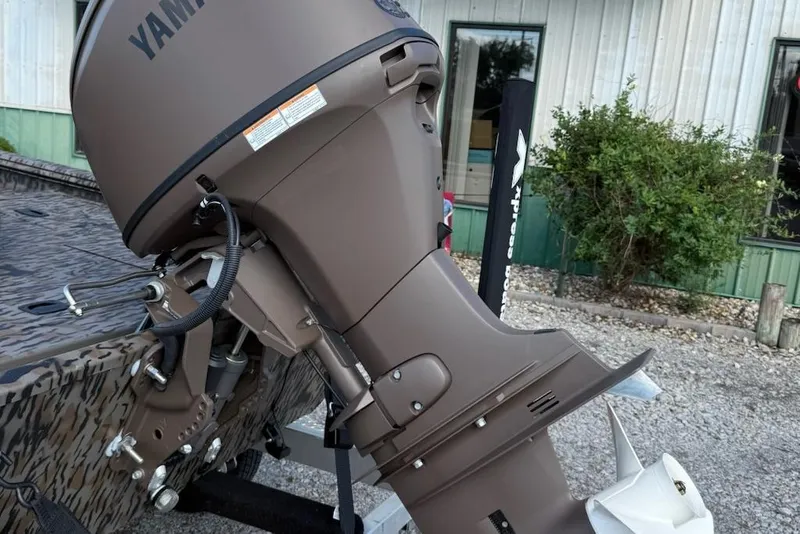 Slide: The Image of Outboard motor on 2026 Express Xp170 boat, parked near a building. - 2