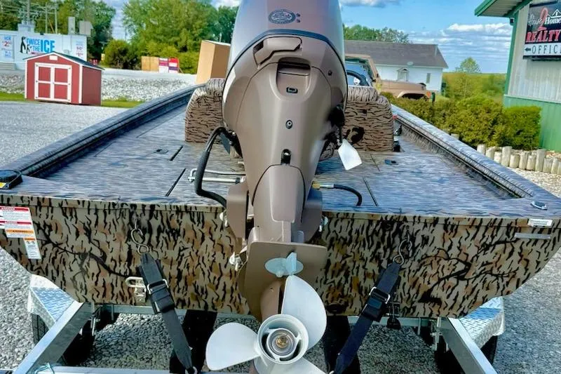 Slide: The Image of 2026 Express Xp170 boat with camouflage design and outboard motor on trailer. - 3