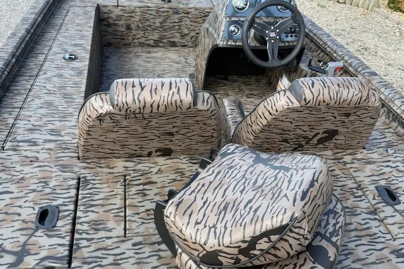 Slide: The Image of Camouflage-patterned interior of 2026 Express Xp170 boat with steering console and seating. - 4