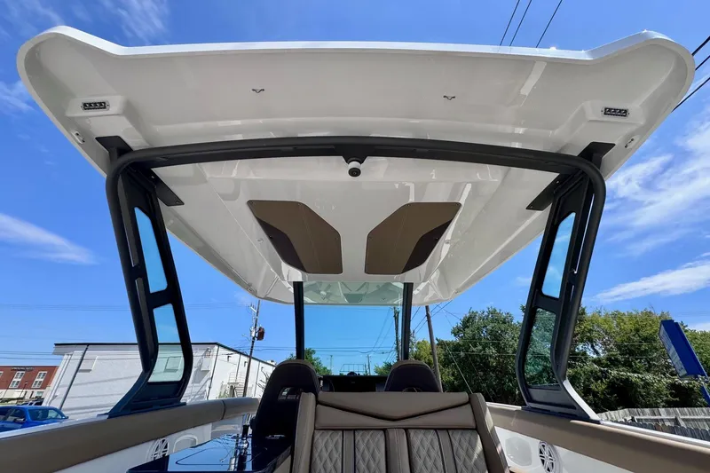 Slide: The Image of 2026 Monterey Elite 30 OB boat with sleek design and modern canopy under a clear blue sky. - 13