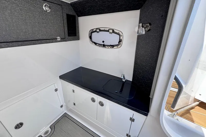 Slide: The Image of Interior of 2026 Monterey Elite 30 OB boat with sleek sink and storage cabinets. - 20