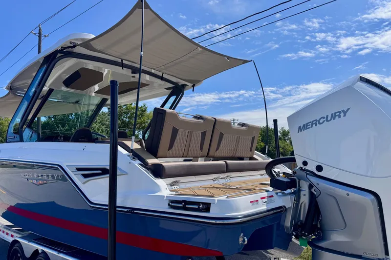 Slide: The Image of 2026 Monterey Elite 30 OB boat with Mercury engine, featuring a spacious deck and canopy. - 24
