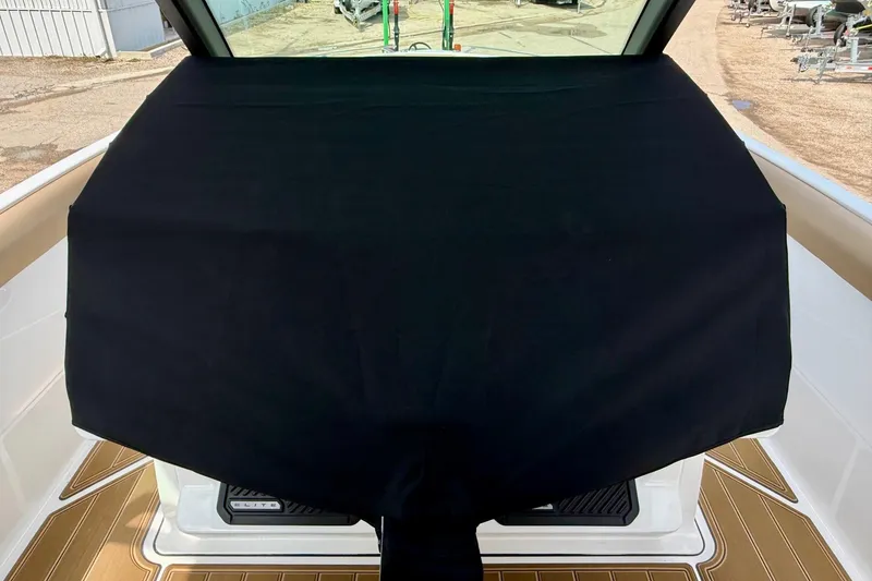 Slide: The Image of 2026 Monterey Elite 30 OB boat with black cover, docked outdoors. - 26