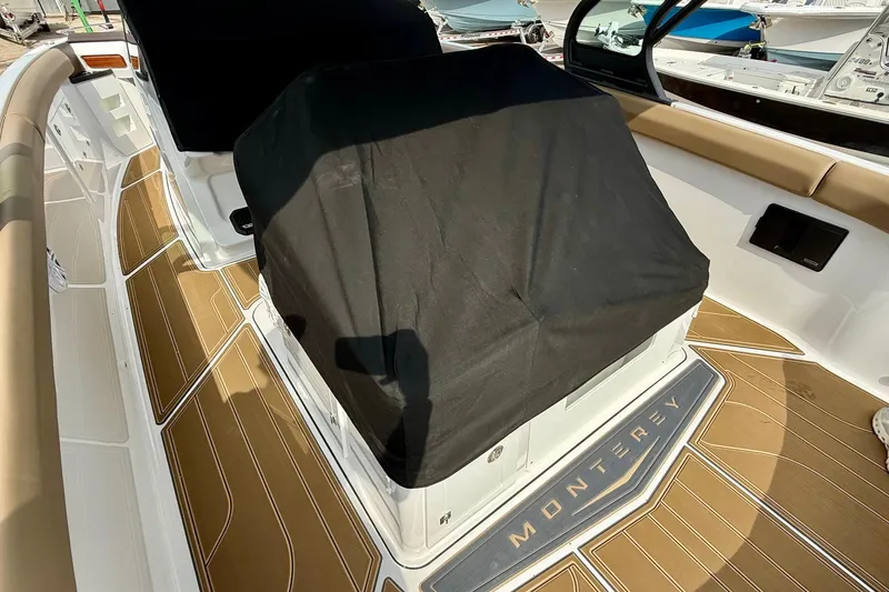 Slide: The Image of 2026 Monterey Elite 30 OB boat interior with covered seating and teak-style flooring. - 27