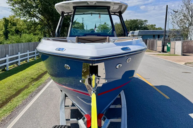 Slide: The Image of 2026 Monterey Elite 30 OB boat on trailer, parked on a suburban street. - 6