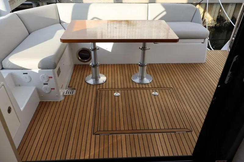 Slide: The Image of Prestige 460 yacht 2023, featuring elegant teak deck and cozy seating area with table. - 40