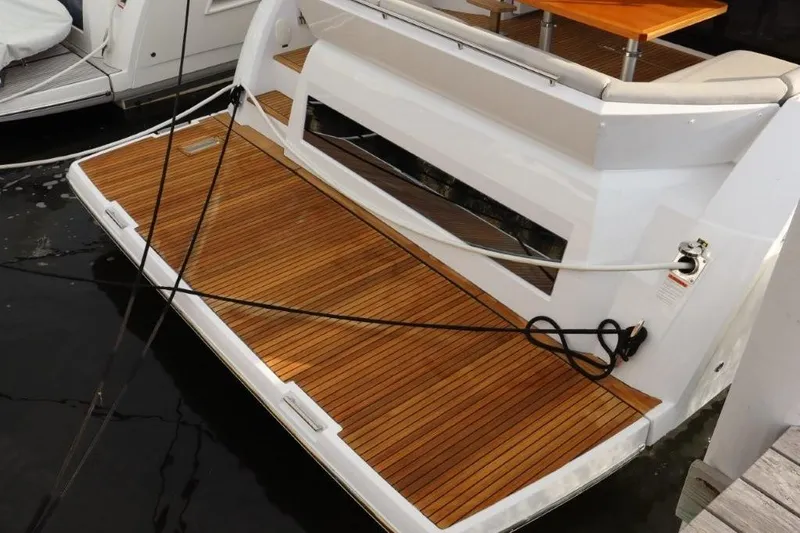 Slide: The Image of 2023 Prestige 460 yacht with teak swim platform and mooring lines. - 50