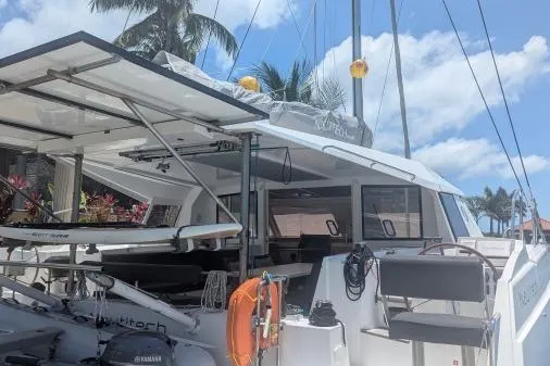 Slide: The Image of 2016 Nautitech 40 Open catamaran docked under palm trees with clear blue sky. - 22